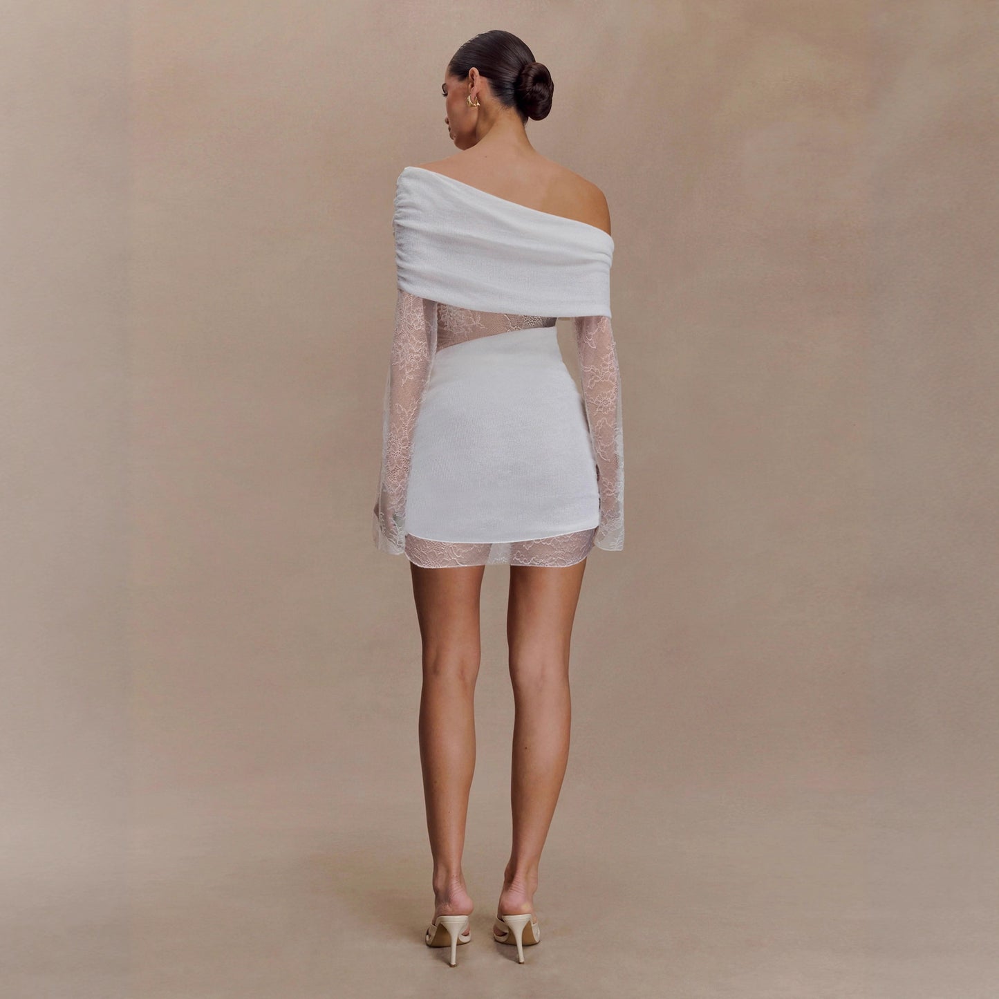 Abito corto bianco con spalla asimmetrica e manica lunga